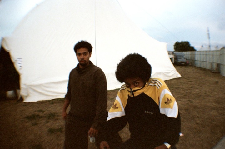 Two friends outside a white tent